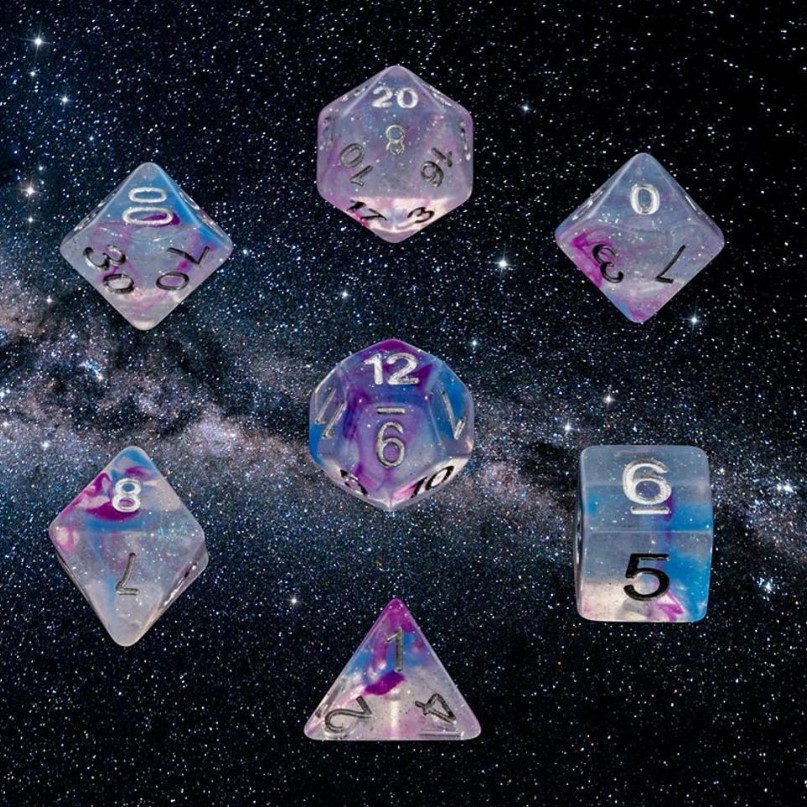 Translucent Dice with streaks of color and glitter reminiscent of stars and the clouds of dust and gas you find floating in space. The numbers are white.